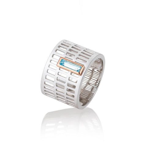 Modern sterling silver ring with rose gold plated accent and an emerald cut blue topaz. By Breuning